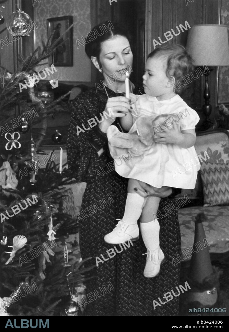 ARKIV 19781207. Drottning Silvia och kronprinsessan Victoria tänder ett ljus vid julgranen under julfotograferingen 7:e december 1978. 1980 ändrade regeringen successionsordningen så att Victoria blir Sveriges tronarvinge.. Foto: Jan Collsiöö / SCANPIX / Kod: 1001. ----------------------------------------------------------------. FILE 19781207. Swedish Queen Silvia and Princess Victoria lighting a candle besides a Christmas tree during a Christmas photo session at the Royal Palace in Stockholm, Sweden on December 7, 1978. Swedish government change the heir apparent in 1980 and first born Princess Victoria became the heir of the throne.. Photo: Jan Collsioo / SCANPIX SWEDEN / Code: 1001.
