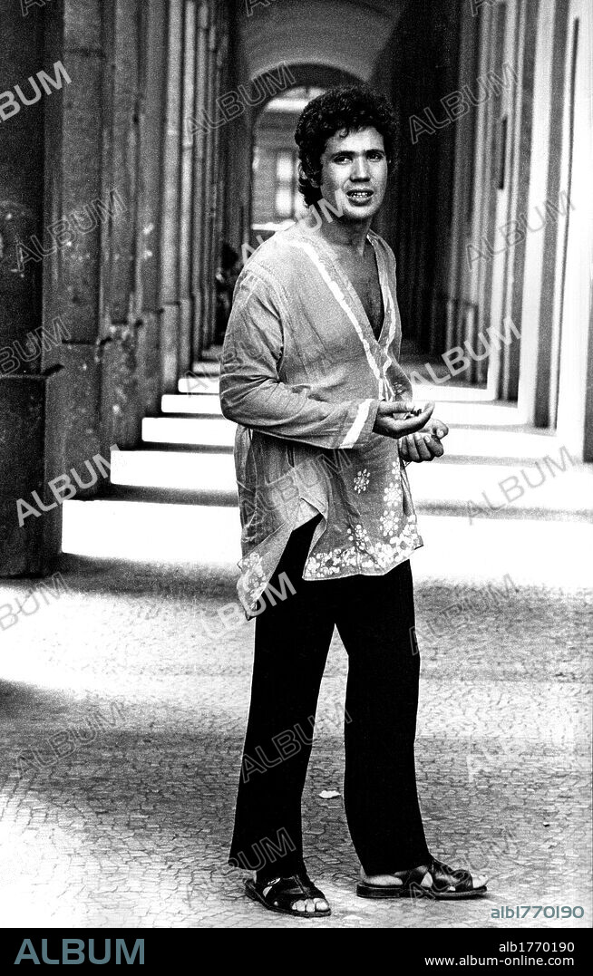 Lucio Battisti under arcades. The Italian musician and singer-songwriter Lucio Battisti posing under arcades. Milan, 1970.