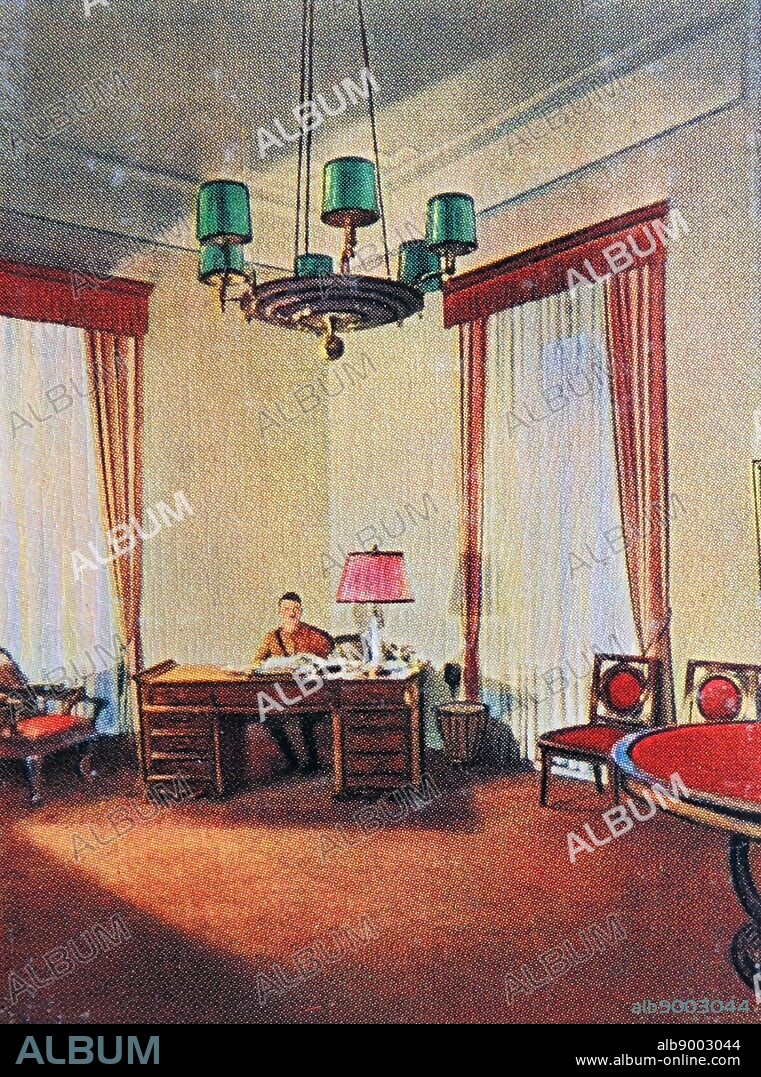 Adolf Hitler sits at a desk in his office before the 1929 election.