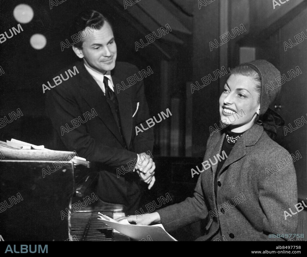 Orig. bildtext... Fönstret den 7/5 1949 fr v Operasångare Åke Colett och Revysångerskan Gitt Gay Anm. Git Gay, eg. Birgit Carp, f. Holmberg, 1921-2007, sångerska och revyprimadonna Pianon Leenden Hättor Publ i RiR 22/49 CD459 persons: GIT GAY;ÅKE COLETT sites: SVERIGE.