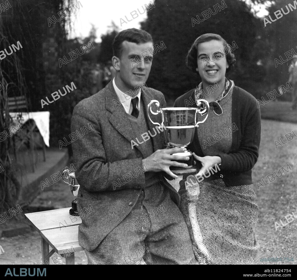 Mixed foursomes golf match at the Worplesdon Golf Club . Mr John Craddock Hartopp and his sister , Miss Gwen Craddock Hartopp , who defeated Miss Jean Hamilton and Mr Stuart Forsyth , receive their trophy . 1935.