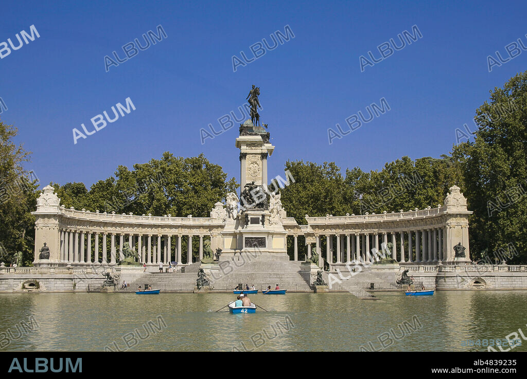 Madrid, Comunidad de Madrid, Spain, Europe.. El Retiro Park (Parque del Retiro). Pannoramic view of the lake and the statue of King Alfonso XII, which is part of a group consisting of a large marble colonnade with numerous sculptures surrounding the bronze statue of the king. The monument, was inaugurated on June 6, 1922 and built by the architect José Grases Riera.
