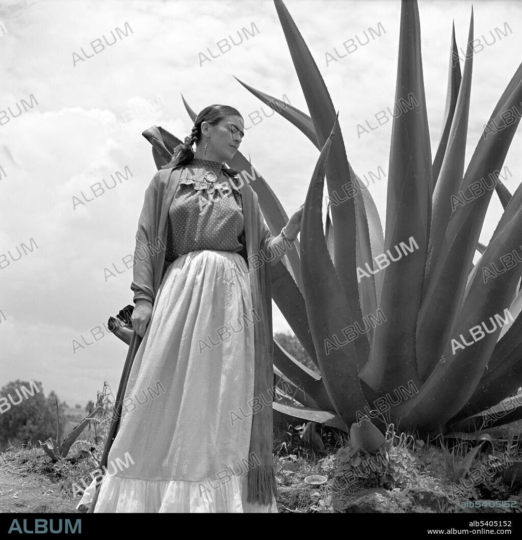 Kahlo, next to an agave plant, during a photo shoot for Vogue magazine, Senoras of Mexico. Frida Kahlo de Rivera (1907 - 1954) was a Mexican artist. During the late 1920s and early 1930s, she developed her own style as an artist, drawing inspiration from Mexican folk culture, and painting mostly self-portraits which mixed elements from pre-Columbian and Catholic mythology.  Photographed by Toni Frissell, 1937.