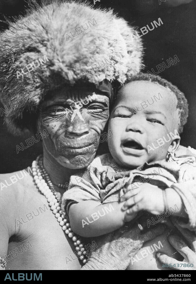 A Bushman of the Kalahari desert and youngster. When birth of a child is imminent, tribal custom is to fete the father well. Bells are then tied to his feet so he can be located to receive the happy news. July 04, 1937. (Photo by Sport & General Press Agency Ltd.).;A Bushman of the Kalahari desert and youngster. When birth of a child is imminent, tribal custom is to fete the father well. Bells are then tied to his feet so he can be located to receive the happy news.
