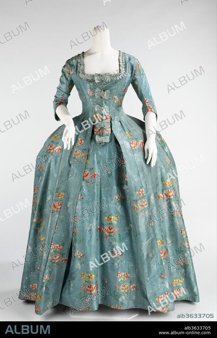 Robe à la Française. Culture: French. Date: 1760-70.
Women with coquettish airs were imposing in robes à la française and robes à l'anglaise throughout the period between 1720 and 1780.  The robe à la française was derived from the loose negligee sacque dress of the earlier part of the century, which was pleated from the shoulders at the front at the back.  The silhouette, composed of a funnel-shaped bust feeding into wide rectangular skirts, was inspired by Spanish designs of the previous century and allowed for expansive amounts of textiles with delicate Rococo curvilinear decoration.  The wide skirts, which were often open at the front to expose a highly decorated underskirt, were supported by panniers created from padding and hoops of different materials such as cane, baleen or metal.  The robes à la française are renowned for the beauty of their textiles, the cut of the back employing box pleats and skirt decorations, known as robings, which showed endless imagination and variety.