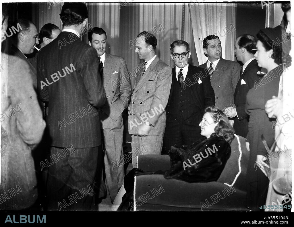 June 1947, Brussels, Belgium. Arrival of Robert Taylor (at the left side) and Barbara Stanwyck (sitting) for the Festival. A official reception was organized by the Mayor Joseph Van de Meulebroeck at the Town Hall. The 2 actors signed some books and pictures of fans. Image by (c) Germaine Van Parys - GermaineImage.