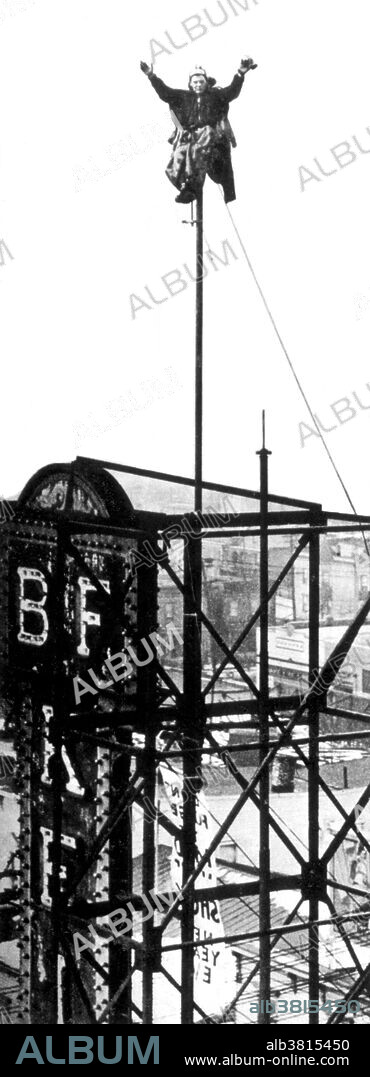 Aloysius Anthony Kelly, AKA Alvin "Shipwreck" Kelly (May 11, 1893 - October 11, 1952), was an American daredevil pole sitter. At the height of his fame he toured 28 cities, charging admission to people who wanted to stand on roofs to see his performance stunts. In 1930 he set a world record by sitting on a flagpole on top of the Steel Pier in Atlantic City, 225 feet high, for 49 days and one hour. He once calculated that over two decades he spent 20,613 hours sitting on flagpoles, of which 210 were in sub-freezing weather and 1400 hours in the rain. While pole sitting, Kelly was said to have subsisted mainly on coffee and cigarettes. He learned how to nap while sitting upright, and never was secured by more than a simple leg strap. In the 1930s there was less tolerance for such stunts, and police took a dim view of the disruption it caused. His last flagpole-sitting appearance was at an Orange, Texas event sponsored by the Lion's Club on October 4, 1952, one week before his death. Kelly died in 1952, at the age of 59, when he was struck by a car while walking on West 51st Street. For a time his body was unclaimed at the morgue. At the time of his death a scrapbook of his exploits was under his arm. He had titled the scrapbook "The Luckiest Fool on Earth." No photographer credited, undated.