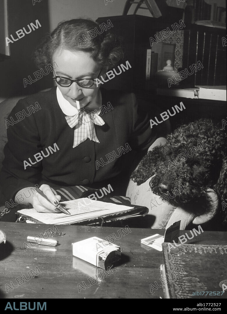 The writer Alba de Céspedes. The Italian writer Alba de Céspedes y Bertini works on some notes in her Rome house, watched by her black poodle. Rome, 23rd February 1955.