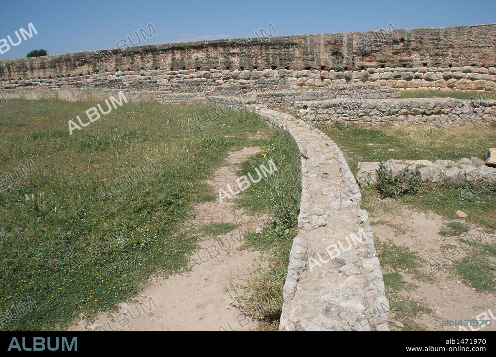 ARTE ROMANO. ESPAÑA. CIUDAD ROMANA DE EMPURIES. Vista parcial del ANFITEATRO (S. I. d. C). Detalle de los restos arqueológicos de las gradas. Construido en época Julio-Claudia. Al fondo la muralla romana (S. I. d. C). Comarca de l'Alt Empordà. Provincia de Girona. Cataluña.