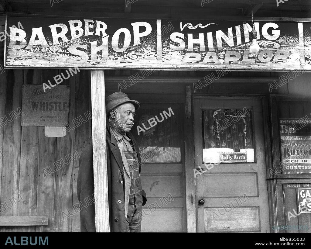 Coal miner standing outside barber shop, Colp, Illinois, USA, Arthur Rothstein, U.S. Farm Security Administration, January 1939.