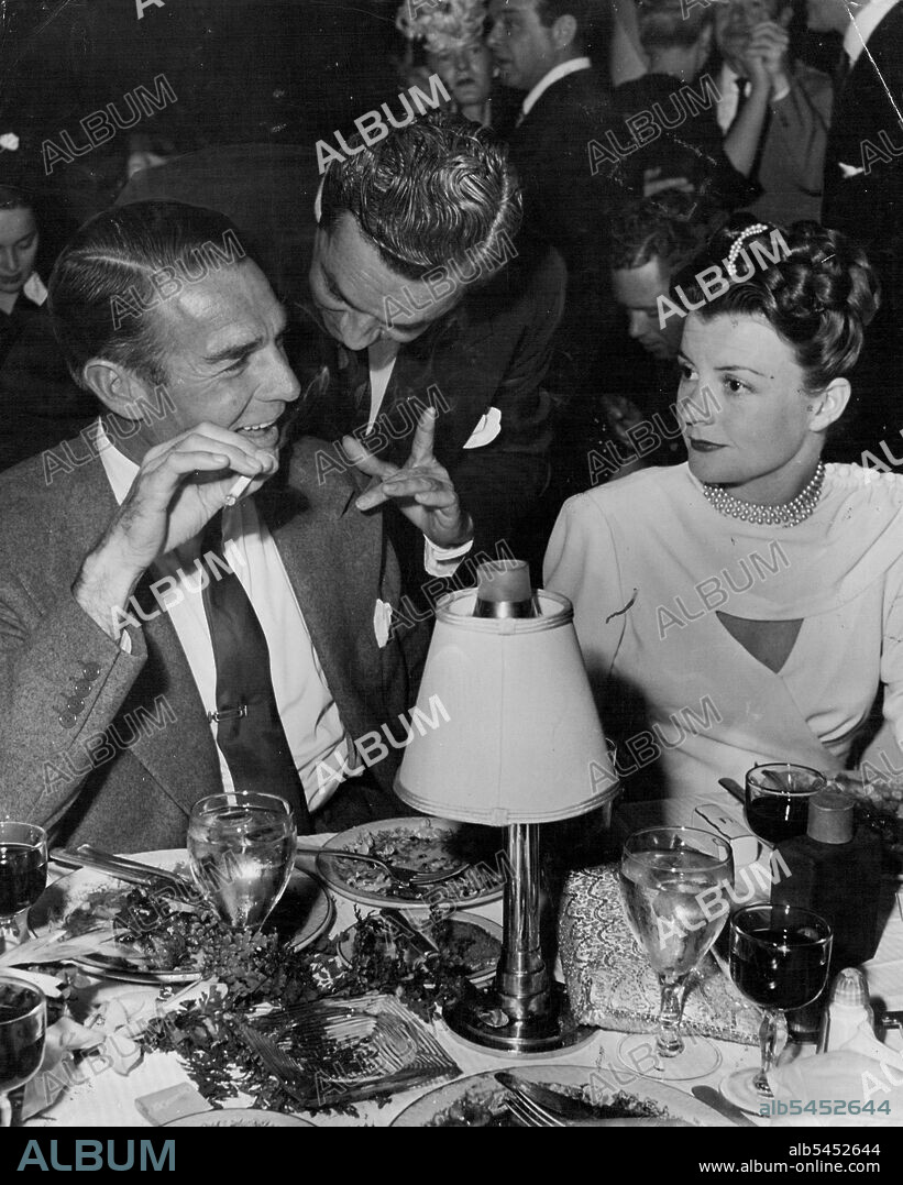 Must be some kind of sign language that Arthur Cameron, spouse of Kay Aldrich and former hubby of June Knight, is trying to get over to Randy Scott and wife, Pat Stillman. September 08, 1946. (Photo by Jay Scott).
