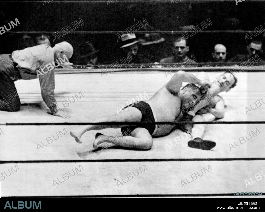Strangler Lewis Retains Title -- Ed (Strangler) Lewis, World's Heavyweight Wrestling Champion, had no difficulty defending his crown against the assault of Dr. Fred Meyers, Chicago's Rappler-Dentist, in Madison Square garden, New York City, night of February 6. Lewis pinned the shoulders of his Rival in 25 minutes, 27 seconds. In the Above Photograph, thing looked bad for a moment for Lewis, (Left), When Meyers got an Arm lock on the Champion. February 6, 1933. (Photo by Associated Press Photo).