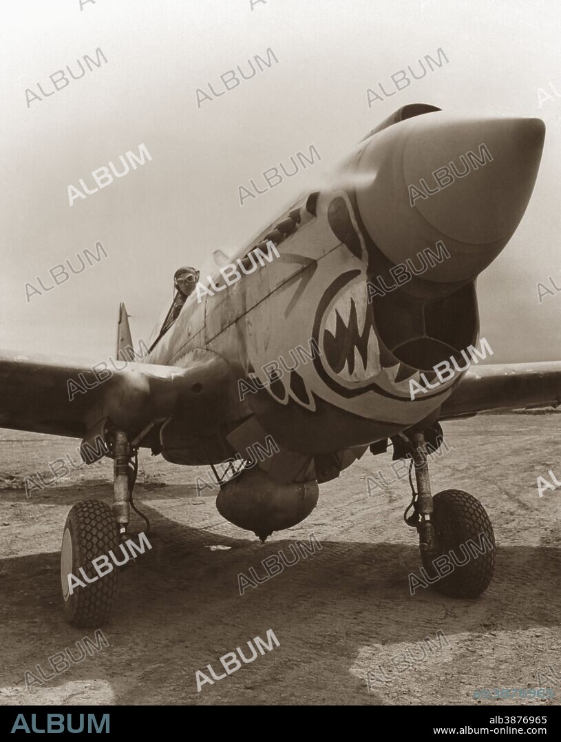 Vintage World War II photo of a P-40 Warhawk plane with a Flying Tigers paint scheme.