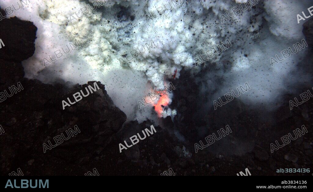 Eruption of the West Mata volcano, discovered in May 2009, occurring nearly 4,000 feet below the surface of the Pacific Ocean, in an area bounded by Fiji, Tonga and Samoa. It is the deepest erupting volcano discovered to date. In this image, an explosion near the summit of the volcano throws ash and rock. Molten lava glows below. Image is about six feet across in an eruptive area of about 100 yards running along the volcano's summit.
