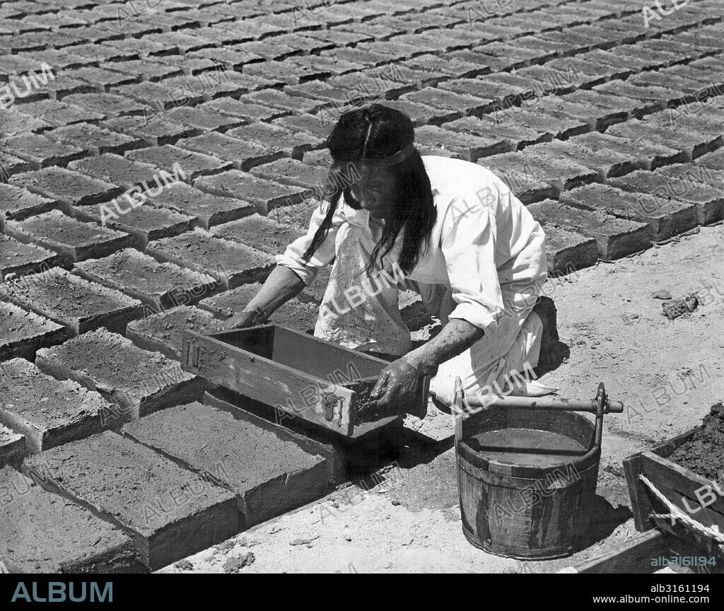 California: c. 1930 The padres taught the Indians to make the adobe bricks used in the building of the missions. The mold was loosened by a careful jiggling motion and then pulled from the formed brick. After every third brick was made, the mold was thoroughly washed to remove the sticky adobe.
