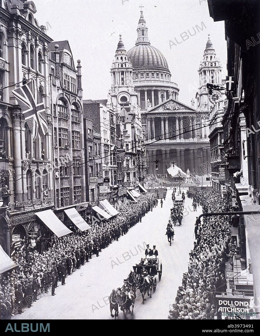 Re-opening of St Paul's Cathedral, London, 1930. View of King George V and Queen Mary, consort of the King, processing down Ludgate Hill, following the re-opening of St Paul's Cathedral on 5th June, 1930. The street is lined with crowds; police keep them off the road. In the bottom right corner there is a shop sign for the opticians Dollond and Aitchison.