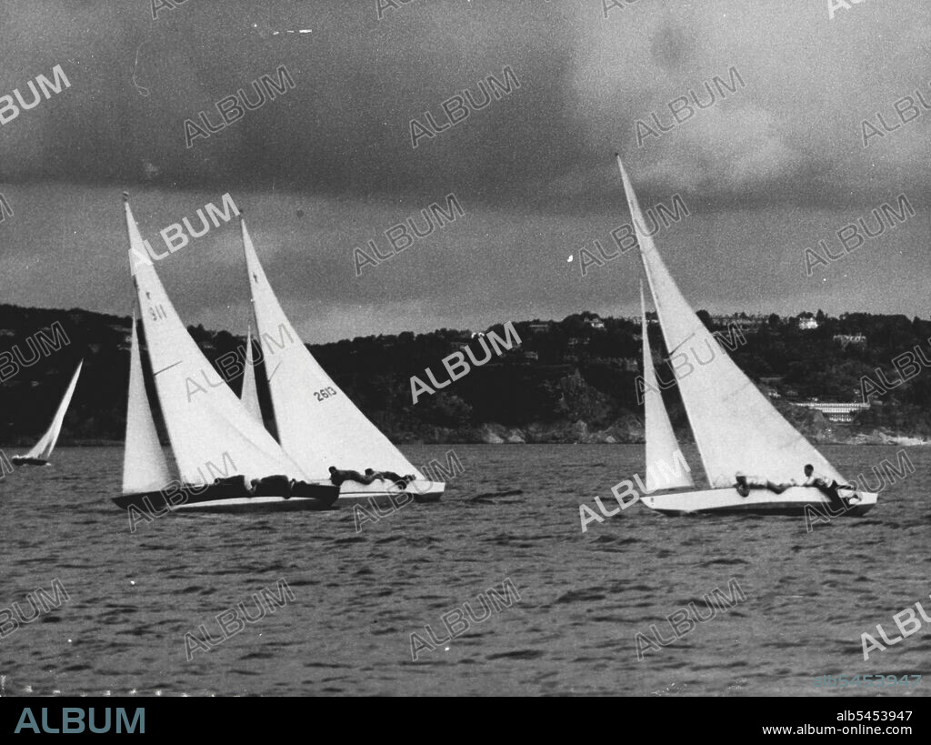 Keen Keelers In Olympic Yachting : Keen Olympic Yachting in the Star Class is seen at Torbay August 11 as crewmen flatten themselves against the decks of their craft to lessen the wind resistance. At left extreme rivalry as two South American entrants strain for the lead. No. 1911 (Nearest Camera) is Argentina's "Acturus" with helmsman J. Piacentini. No. 2613 is Brazil's "Buscape 11" with Helmsman J. J. Bracony. Yacht at right is unidentified. August 12, 1948. (Photo by Olympic Photo Association).