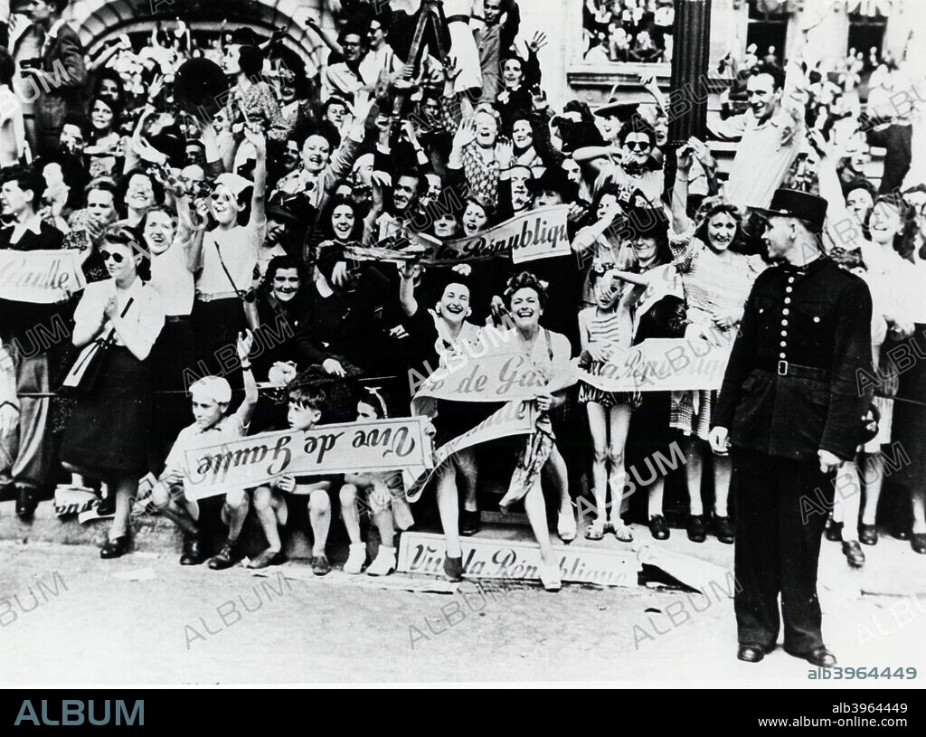 World War 2: Liberation of Paris, 1944. French civilians celebrating the Liberation and holding banners saying 'Vive la Republique' and 'Vive de Gaulle'.