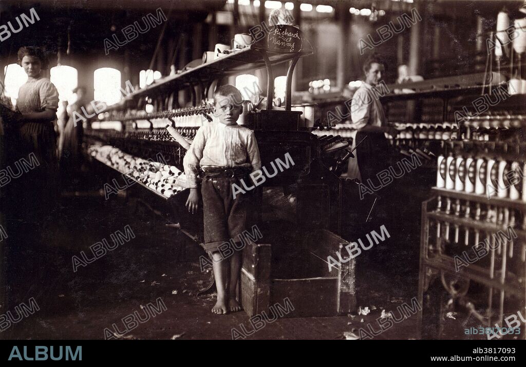 Entitled: "Leo, 48 inches high, 8 years old. Picks up bobbins at 15 cents a day in Elk Cotton Mills. He said, "No, I don't help me sister or mother, just myself." Location: Fayetteville, Tennessee." Cotton mills were designed to move cotton through a precise series of production processes that separated, straightened, and twisted cotton fibers, combined them into yarn, then wove the yarn into cloth. Workers directed four or more slivers through a series of rollers in the head of a drawing frame, where they were combined in a single strand. As bobbins on the spinning frames filled with thread, doffers replaced them with empty ones. The spinner's job was to move quickly up and down a row of machines, repairing breaks and snags. Child labor refers to the employment of children in any work that deprives children of their childhood, interferes with their ability to attend regular school, and that is mentally, physically, socially or morally dangerous and harmful. Photographed by Lewis Hine, November 1910.