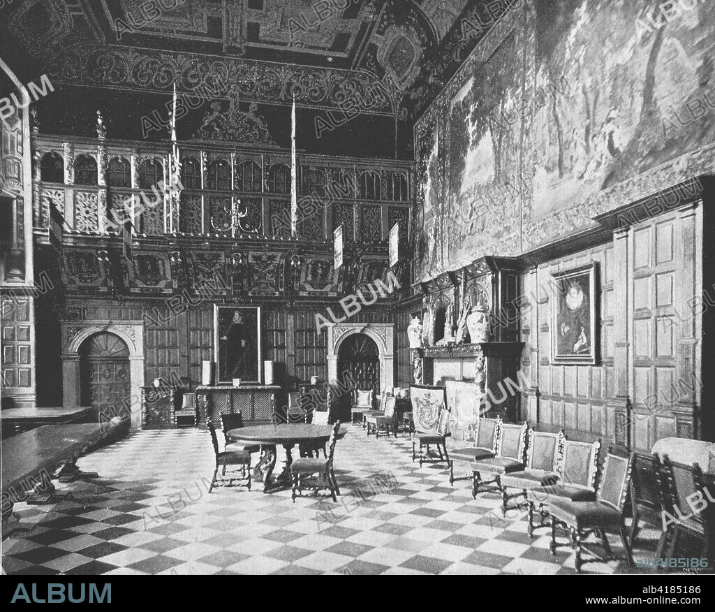 The Great Hall, Hatfield House, Hatfield, Hertfordshire, 1894. The Marble Hall, with oak carving by John Bucke, dates from 1611. The room takes its name from the chequered black and white marble floor, while panels featuring classical themes were painted by Giulio Taldini. Built in 1485, the Royal Palace of Hatfield was where Elizabeth I spent some of her childhood. The present house was built in 1611 by Robert Cecil, 1st Earl of Salisbury, Chief Minister to King James I. From Beautiful Britain; views of our stately homes. [The Werner Company of Chicago, 1894].