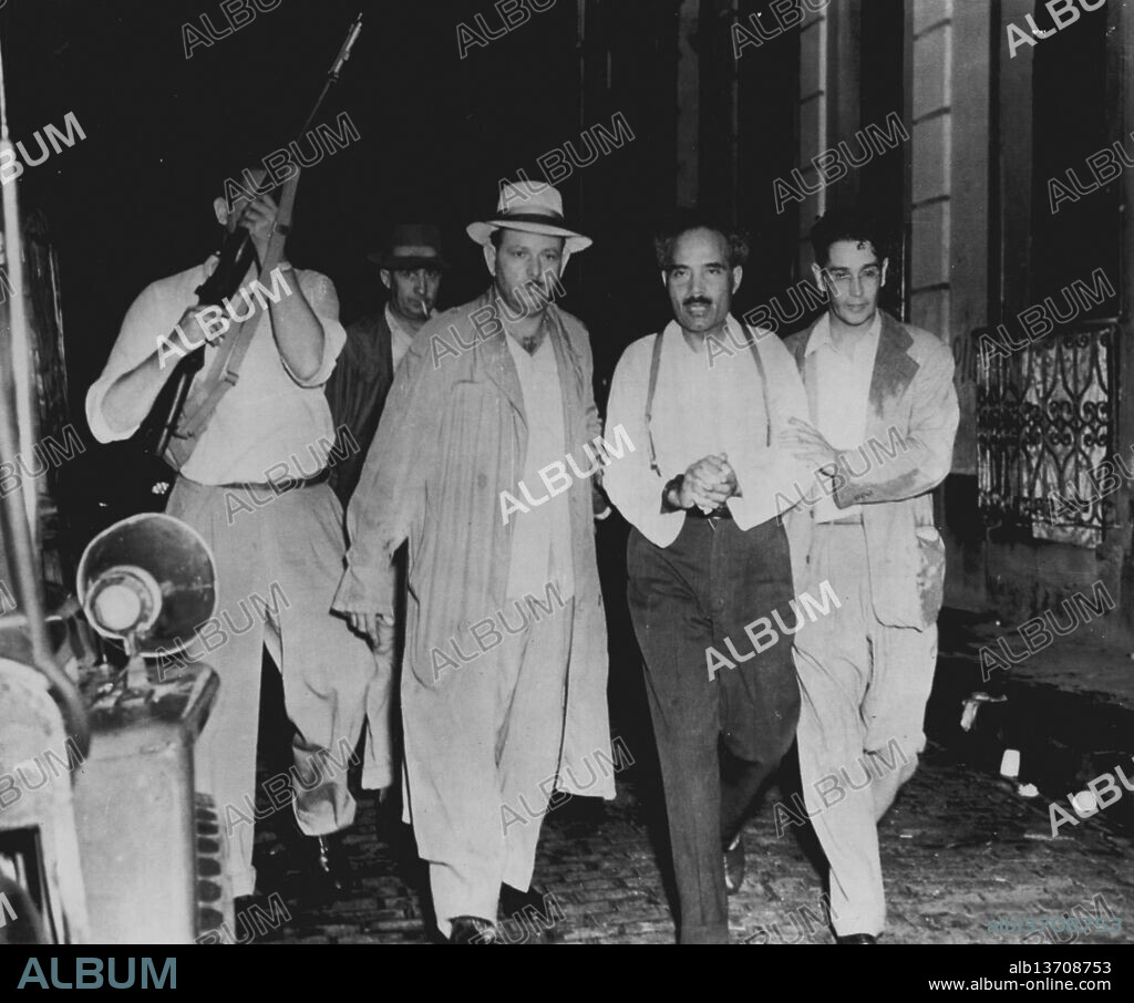 Puerto Rican Nationlist Leader Arrested -- Deputy Police lead Pedro Albizu Campos  (second from right) from his home in San Juan, Puerto Rico, today after the Puerto Rican Nationalist party leader was placed under arrest. He was locked up in an island-wide roundup touched off by the Puerto Rican revolt and the attempt in Washington on the life of President Truman. This photo was made by Juan E. Ortiz of the magazine Alma Latina of San Juan. November 02, 1950. (Photo by AP Wirephoto).
