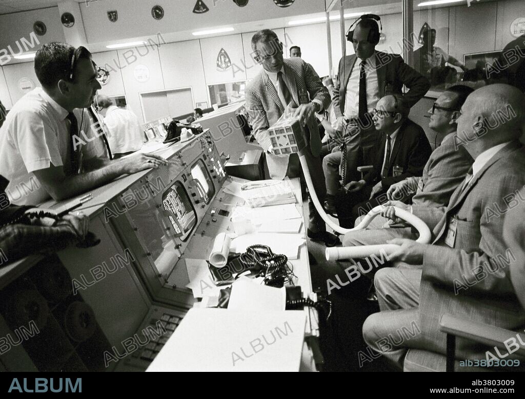 Prototype of the "mail box" constructed at the Manned Spacecraft Center (MSC) to remove carbon dioxide from the imperiled Apollo 13 Command Module (CM) is displayed at the Mission Control Center, Houston, on April 15, 1970. The device was constructed when it became apparent that the crew was in danger of CO2 building to dangerous levels in the CM. A spacesuit exhaust hose would be connected to a lithium hydroxide canister to purge the cabin air. Present at mission control are (from the left): Milton L. Windler, shift 1 flight director; Dr. Donald K. (Deke) Slayton, director of flight crew operations, MSC; Howard W. Tindall, deputy director, flight operations, MSC; Sigurd A. Sjoberg, director, flight operations, MSC; Dr. Christopher C. Kraft, deputy director, MSC; and Dr. Robert R. Gilruth, director, MSC. The Apollo 13 craft and crew launched on April 11, 1970, but when an oxygen tank exploded two days later rendering the Service Module ineffective, the mission was aborted. The crew returned safely to Earth on April 17. NASA followed this mission with Apollo 14 in January 1971, which saw a successful Moon landing and safe return of its crew.