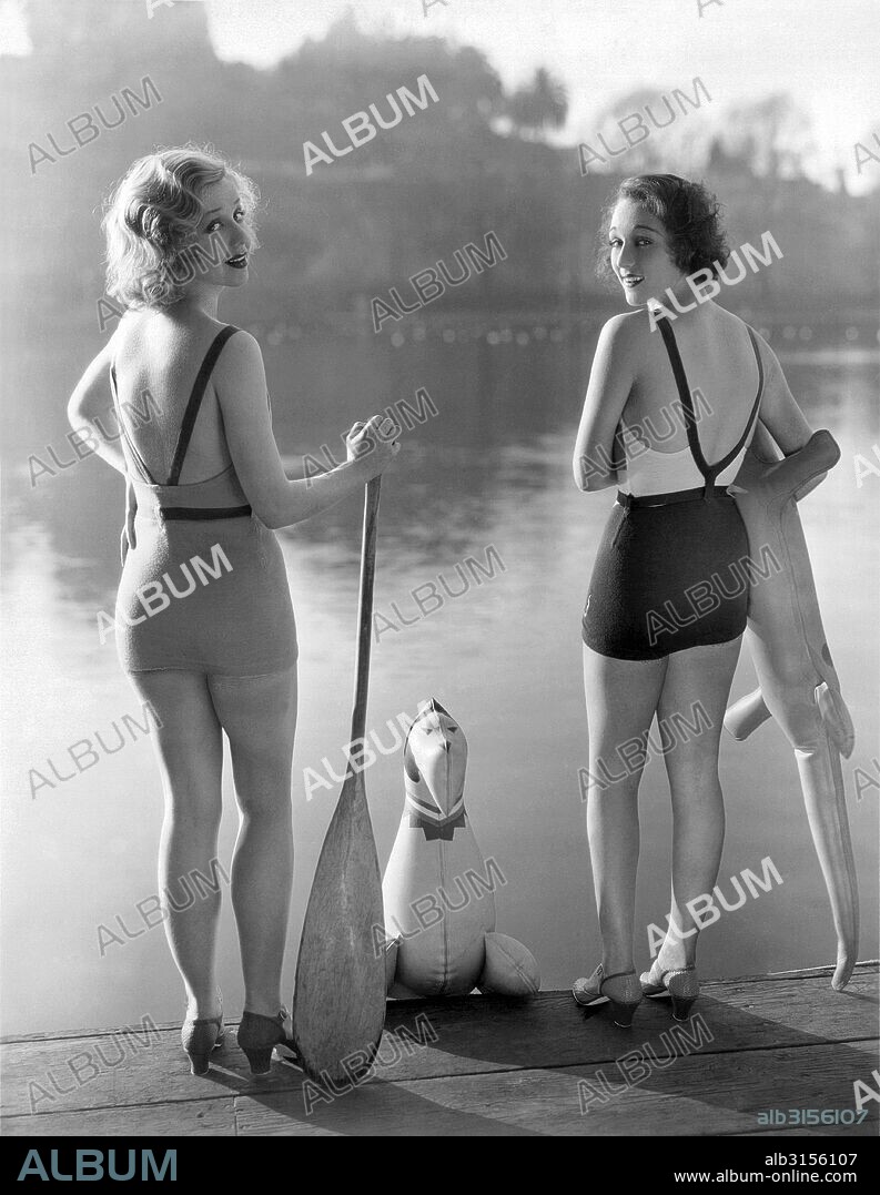 Los Angeles, California:  c.1935. Bathing beauties Adrienne Dore and Mae Madison look ready to take the plunge in their backless bathing suits.