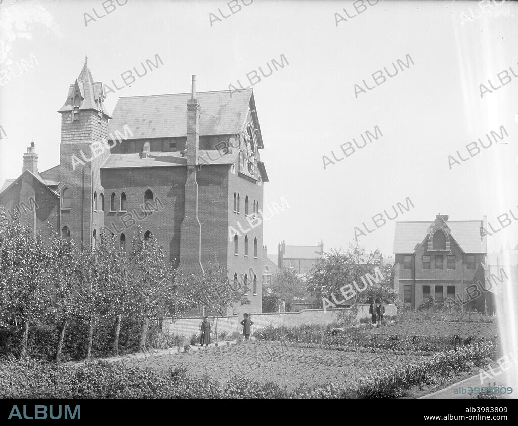 Society of St John The Evangelist, Mission House, Cowley, Oxford, Oxfordshire,  c1860-c1922. View of the house looking across the garden, also showing chapel.