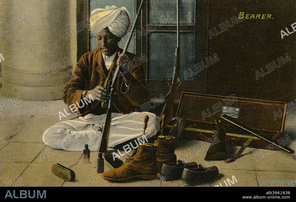 Bearer, c1910. The bearer was a man's personal servant who would run the household of a bachelor sahib. Here we see the Bearer cleaning a rifle. From a post card produced by Moorli Dhur & Sons, Ambala.