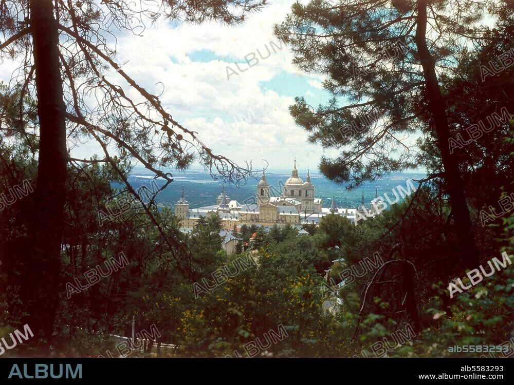 El Escorial (Spain), (Residency and burial site of the Spanish royalty; built 1563 under Phillip II by Juan Bautista de Toledo and Juan de Herrera). Genaral view from the pine forest in the nearby mountains. Photo.