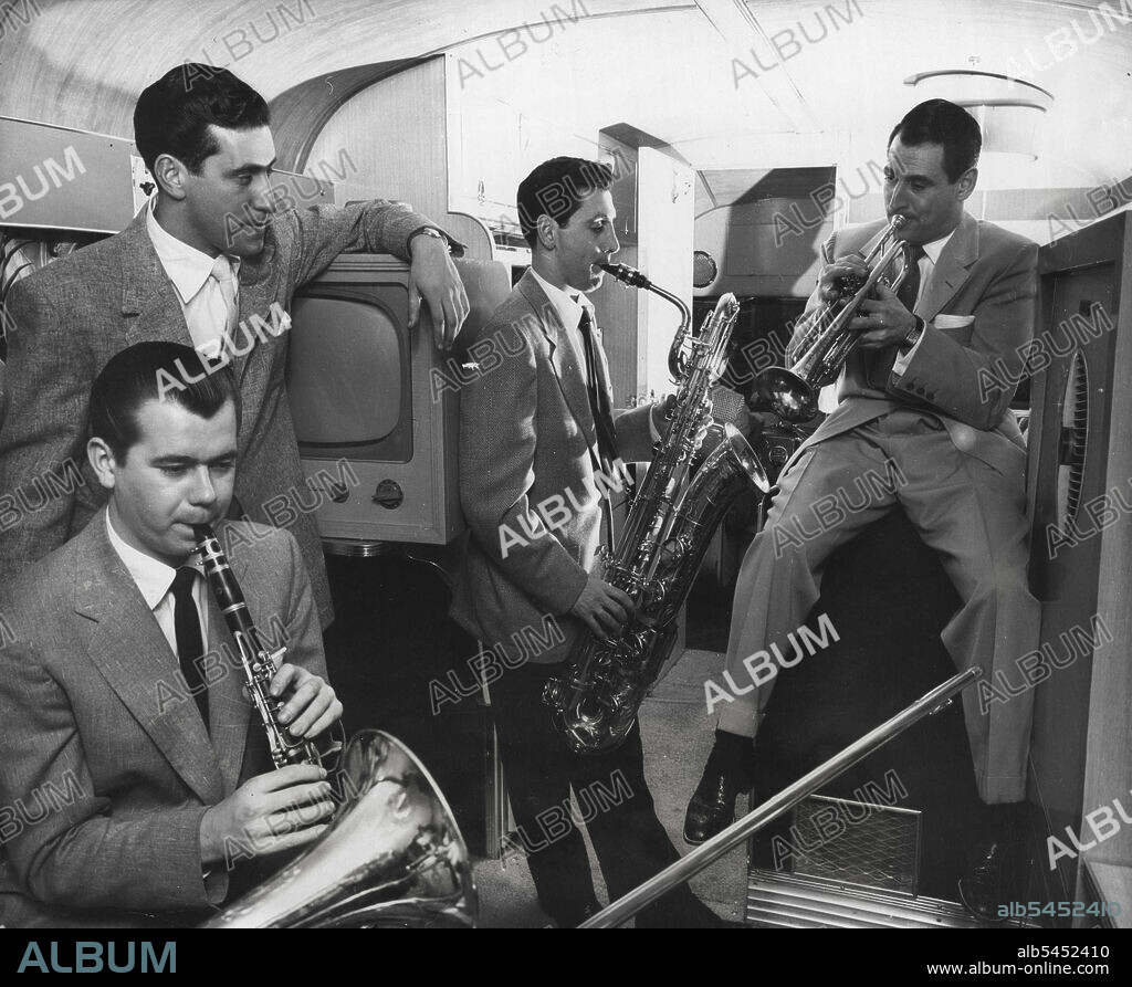 An impromptu Jam session is held in the Anthony Home, and the boys are really Rollins. The maestro mans the trumpet (right), with his driver (background) at the wheel. These sessions are not new on buses carrying touring Bandsman, but the old passenger-style decor was never like this! January 09, 1953. (Photo by United Press).