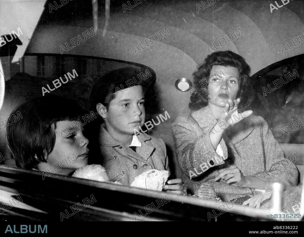 Rita Hayworth with her daughters, Yasmin (left) and Rebecca, pictured as they drove to Paris yesterday from Cherbourg. The serious-faced actress said: "Aly and P'are on the best of terms. We are very friendly". 
Actress Rita Hayworth is whirling around Paris in one of Aly Khans cars and daily receiving huge hunches of lowers from him.
Paris society is already tipping that Aly and Rita will re-marry.
Pictured above are Yasmin (left), Aly Khans daughter; Rebecca, 10 - year - old daughter of Orson Welles; and Rita Hayworth. October 4, 1955.