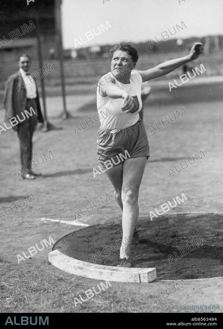 Orig. bildtext... DEUTSCHE FRAUEN-MEISTERSCHAFTEN AUF DEM S.C.C.-SPORTPLATZ AM 15.7.28. Fräulein Heublein-Barmen, die mit 11,96 m einen neuen Weltrekord im Kugelstossen aufstellte. Anm. Heublein, Margarete (Grete), 1908-1997, tysk friidrottare, slog världsrekord i diskus och flera gånger i kulstötning, kortdistanslöpare (100 m) Idrottskvinnor Utomhussport Styrkesport Kampanda Blicken Muskler Ben Idrottsarenor Idrottskläder Utkast Rekordhållare Vinnare Världsrekordhållare persons: MARGARETE (GRETE) HEUBLEIN sites: TYSKLAND.