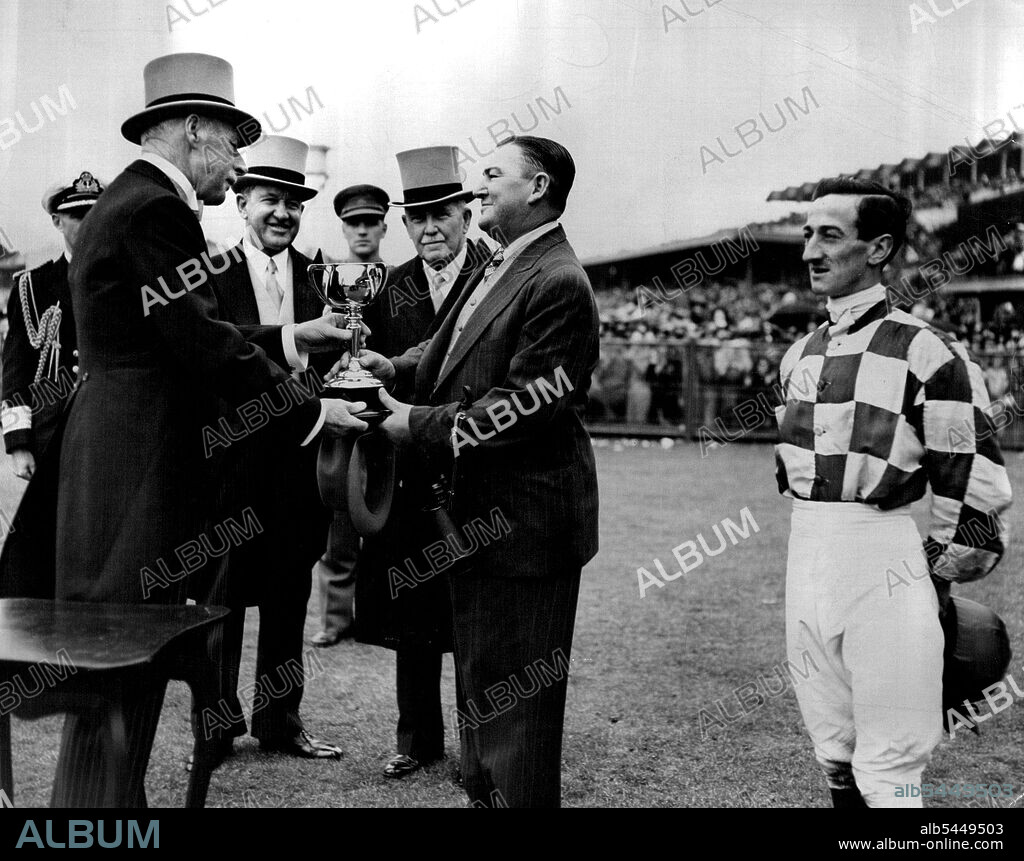 Presentation of Melb Cup by returns Governor of Vic Sir Winston Dugan. The ceremony was performed by Sir Winston at ***** of ***** Gov General M. McKell because Sir Winston learning for England.Looking a little as though he really shouldn't be there, Purtell stands by during the presentation of the 1947 ***** November 6, 1947.