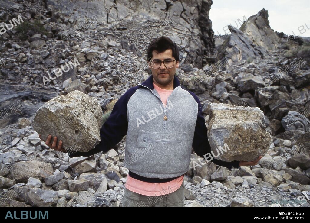Geologist Abel Ramirez hefts two pumice boulders. Because of the large number of air pockets, pumice is relatively light. Panum Crater, California.
