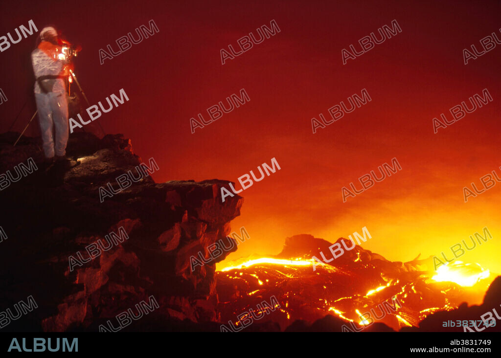 A photographer in a heat-resistant suit photographs lava flow from Hawaii's Kilauea volcano, October 3, 2001.
