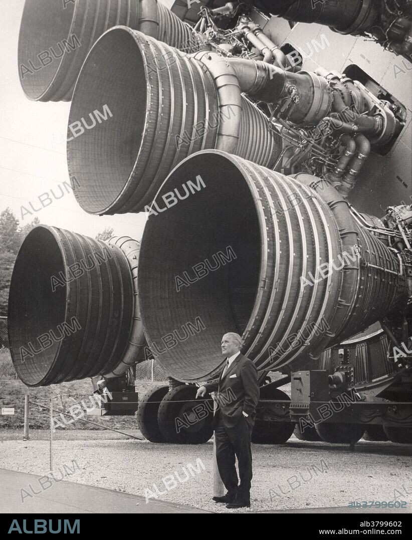 Wernher von Braun (1912-1977), German rocket scientist, standing by the engines of the huge Saturn V rocket that he helped design. The Saturn V rocket was designed for the Apollo program to take astronauts to the Moon. It achieved this in 1969. Von Braun started his career in Nazi Germany, and was responsible for the long-range V-1 and V-2 missiles. These caused considerable damage and deaths to their targets. Von Braun was arrested for dissent by the Nazis. After his release he surrendered to US forces. He first worked on missiles for the US military before joining NASA soon after its foundation.Photographed at the Space Rocket Center in Huntsville, Alabama.