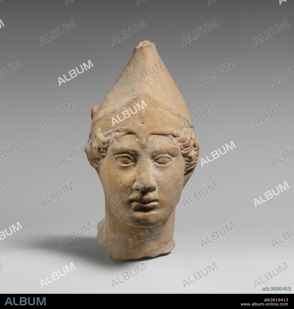 Terracotta head of a youth. Culture: Greek, South Italian, Tarentine. Dimensions: H. 3 1/2 in. (8.89 cm). Date: late 5th-4th century B.C..
The youth wearing a pilos (pointed helmet) is a common type among Tarentine terracottas. In earlier scholarship, these figures were identified as the Dioskouroi, Kastor and Polydeukes, who with their sisters Helen and Klytamnestra, were offspring of Leda. The identity of the youths is now undefined.