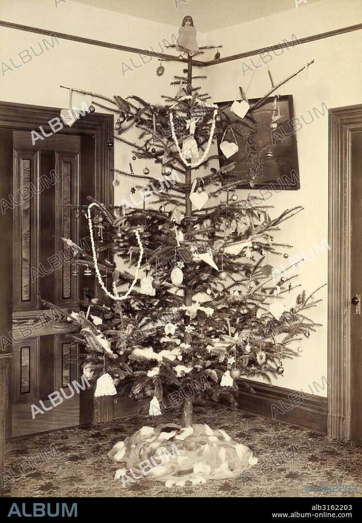 United States: c. 1900. A Christmas tree in a house with many handmade decorations.