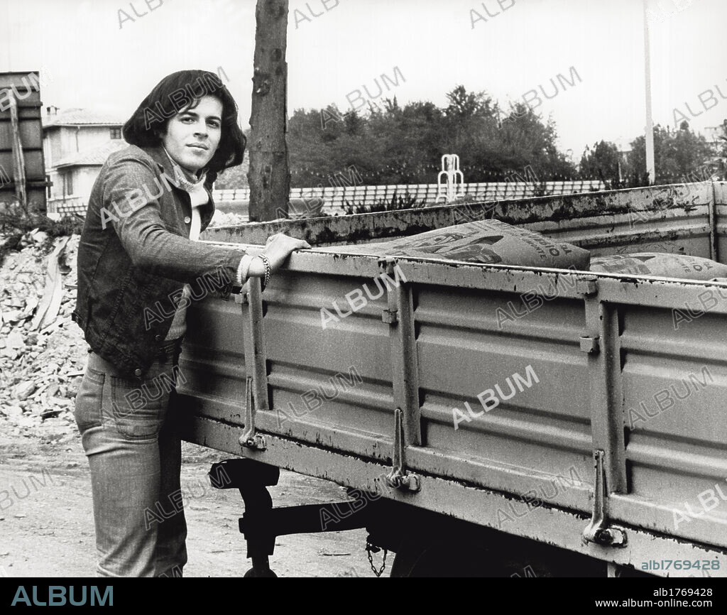 Claudio Baglioni in the outskirts of Rome. The Italian singer Claudio Baglioni in the outskirts of the city while leaning against a lorry. Rome, 1974.