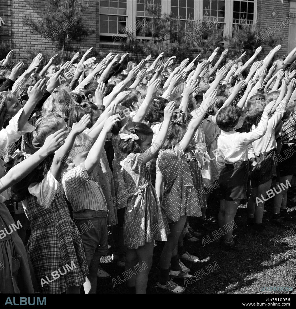School children pledging their allegiance to the flag Southington, Connecticut photographed by Fenno Jacobs, May 1942. The Pledge of Allegiance is a solemn vow of loyalty and support for the country. "I pledge allegiance to the flag of the United States of America, and to the republic for which it stands, one nation under God, indivisible, with liberty and justice for all." The Pledge of Allegiance first appeared in 1892 in a children's magazine. The phrase under God, added in 1954, has inspired heated debate over the separation of church and state. Swearing of the Pledge is accompanied by a salute. An early version of the salute, adopted in 1892, was known as the Bellamy salute. It started with the hand outstretched toward the flag, palm down, and ended with the palm up. Because of the similarity between the Bellamy salute and the Nazi salute, developed later, the United States Congress instituted the hand-over-the-heart gesture as the salute to be rendered by civilians during the Pledge of Allegiance and the national anthem in the United States, instead of the Bellamy salute. Removal of the Bellamy salute occurred on December 22, 1942, when Congress amended the Flag Code language first passed into law on June 22, 1942.