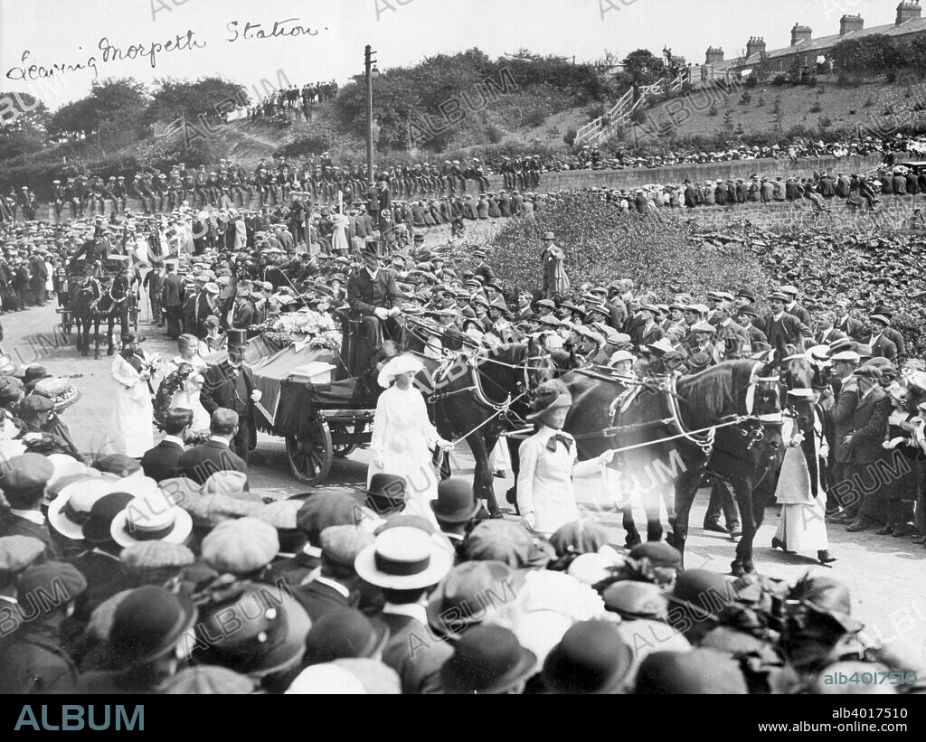 A large crowd watches Emily Wilding Davison's funeral procession leaving Morpeth station, 15th June 1913. She died after stepping out in front of King George V's horse at the Derby at Epsom. On this day every year, up to the late 1960s, suffragettes would visit Morpeth on the 'Emily Davison Pilgrimage'. In 1915, her friend Mary Leigh, far left in the photograph with her head bowed, started the 'Emily Davison Club', and the 'Emily Davison Lodge', whose aim was: 'to perpetuate the memory of a gallant woman by gathering together women of progressive thought and aspiration with the purpose of working for the progress of women according to the needs of the hour'.