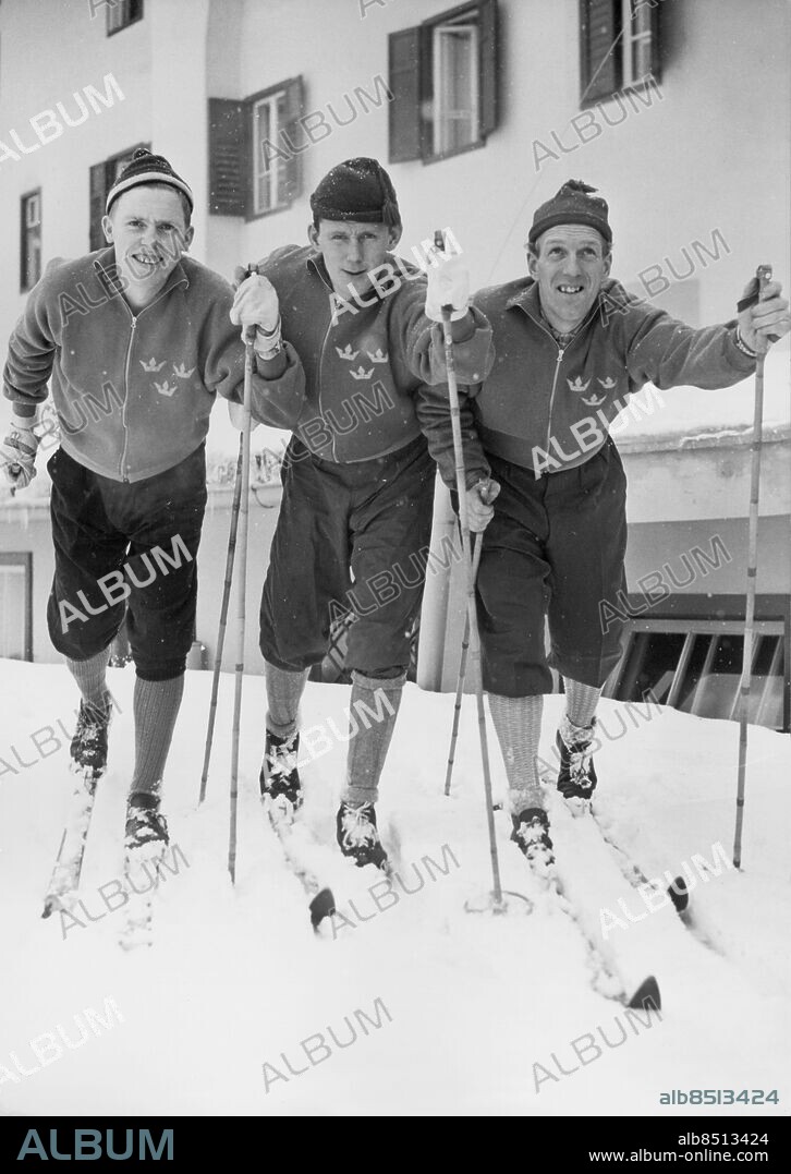 Orig. bildtext... OLYMPIADEN I CORTINA. Stig Gunnarssson, Manfred Mattsson och Artur Olsson startar en träningstur utanför hotell Menardi. 19-1-56. Anm. A Olsson, f. 1928, svensk längdskidåkare. Vinter-OS OS i Cortina 1956 Längdskidåkning Stavar Skidor Tre kronor Symboler Idrottsmän Idrottskläder Strumpor Mössor persons: ARTUR OLSSON;MANFRED MATTSSON;STIG GUNNARSSON sites: SVERIGE*;ITALIEN;CORTINA.