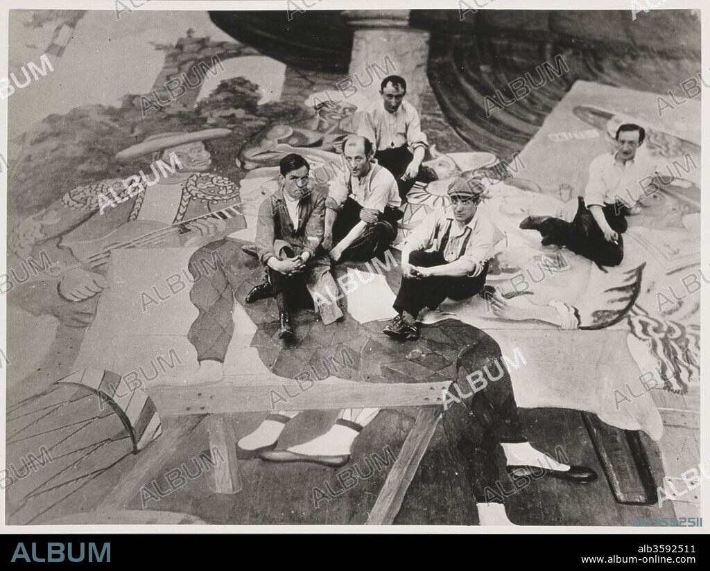 HARRY LACHMAN. Picasso and his assistants sitting on the curtain for the ballet Parade.