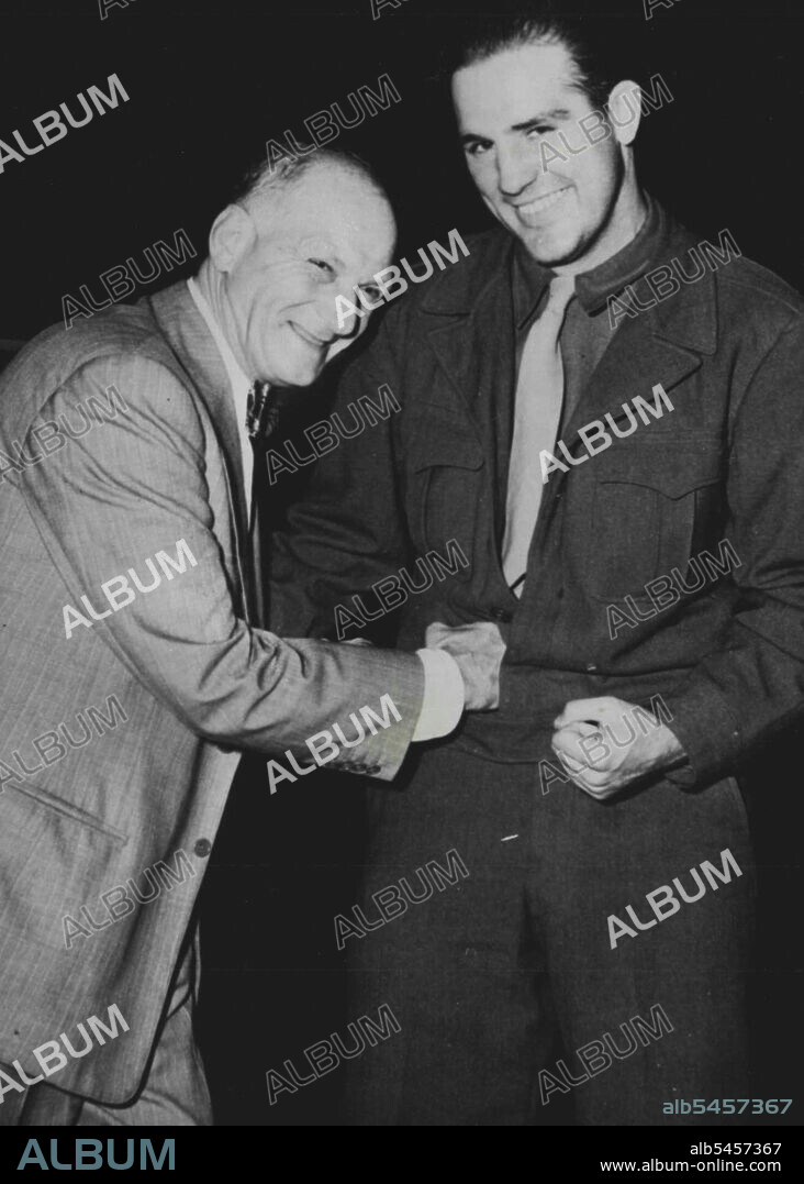 Conn Comes Home - Grinning Capt. Billy Conn, number one challenger for Joe Louis heavyweight boxing title, lets "The ***** slip one in ***** of greeting as the fighter arrives at Laguardia field early on the morning of Sept. 11th. "The Boss," on hand greet his boy when Conn returned from a 15-month boxing tour of ***** sponsored by the army. November 9, 1945. (Photo by ACME).