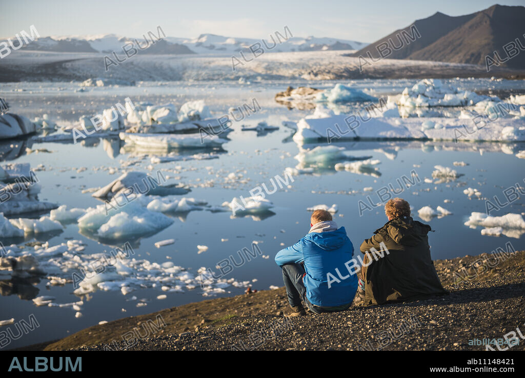 Father and son on holiday at Jokulsarlon Glacier Lagoon at sunset, South East Iceland, Iceland, Polar Regions.