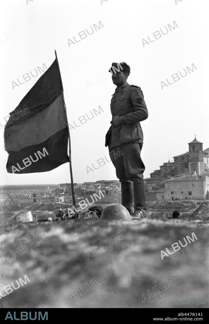 España. Guerra civil (1936-1939). Falange española y de las J.O.N.S. División 72 del Cuerpo del Ejército de Castilla. Flechas Verdes, junto a legionarios del Corpo Truppe Volontaire, CTV, formaron una unidad mixta italo-española movilizada para hacer frente en la ofensiva de Catalunya al final de la contienda.  Oficial junto a la bandera en la posición de la Dirección de las Flechas Negras.