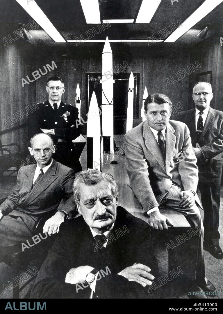 Hermann Oberth (forefront) with officials of the Army Ballistic Missile Agency at Huntsville, Alabama in 1956. Left to right: Dr. Ernst Stuhlinger (seated); Major General H.N. Toftoy, Commanding Officer and person responsible for Operation Paperclip, which took scientists and engineers out of Germany after WWII to design rockets for American military use. Many of the scientists later helped to design the Saturn V rocket that took the Apollo 11 astronauts to the Moon. Dr. Eberhard Rees, Deputy Director, Development Operations Division Wernher von Braun, Director, Development Operations Division.