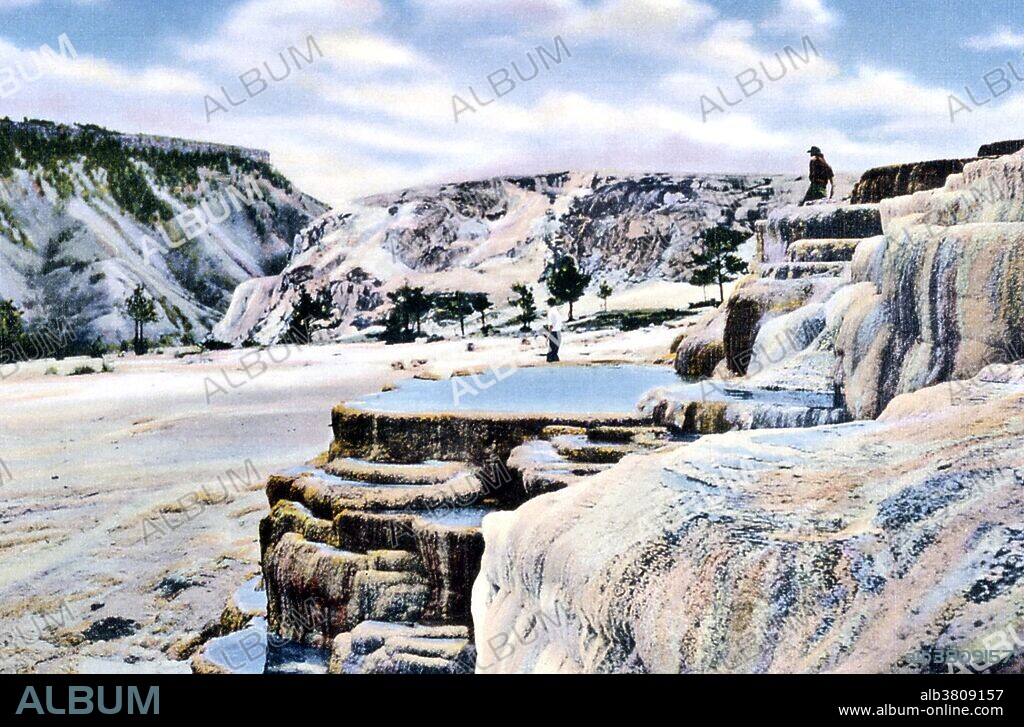Due to confusion related to the intermittent nature of many of the springs in the Mammoth Area, the name Cleopatra Spring has been given to at least three different springs over the years. As the confusion developed the original Cleopatra Spring came to be called Minerva Spring. Mammoth Hot Springs is a large complex of hot springs on a hill of travertine in Yellowstone NP adjacent to Fort Yellowstone and the Mammoth Hot Springs Historic District. It was created over thousands of years as hot water from the spring cooled and deposited calcium carbonate (over two tons flow into Mammoth each day in a solution). Although these springs lie outside the caldera boundary, their energy has been attributed to the same magmatic system that fuels other Yellowstone geothermal areas. Yellowstone National Park is a national park located primarily in the state of Wyoming, although it also extends into Montana and Idaho. Photographed by Frank J. Haynes, 1920.
