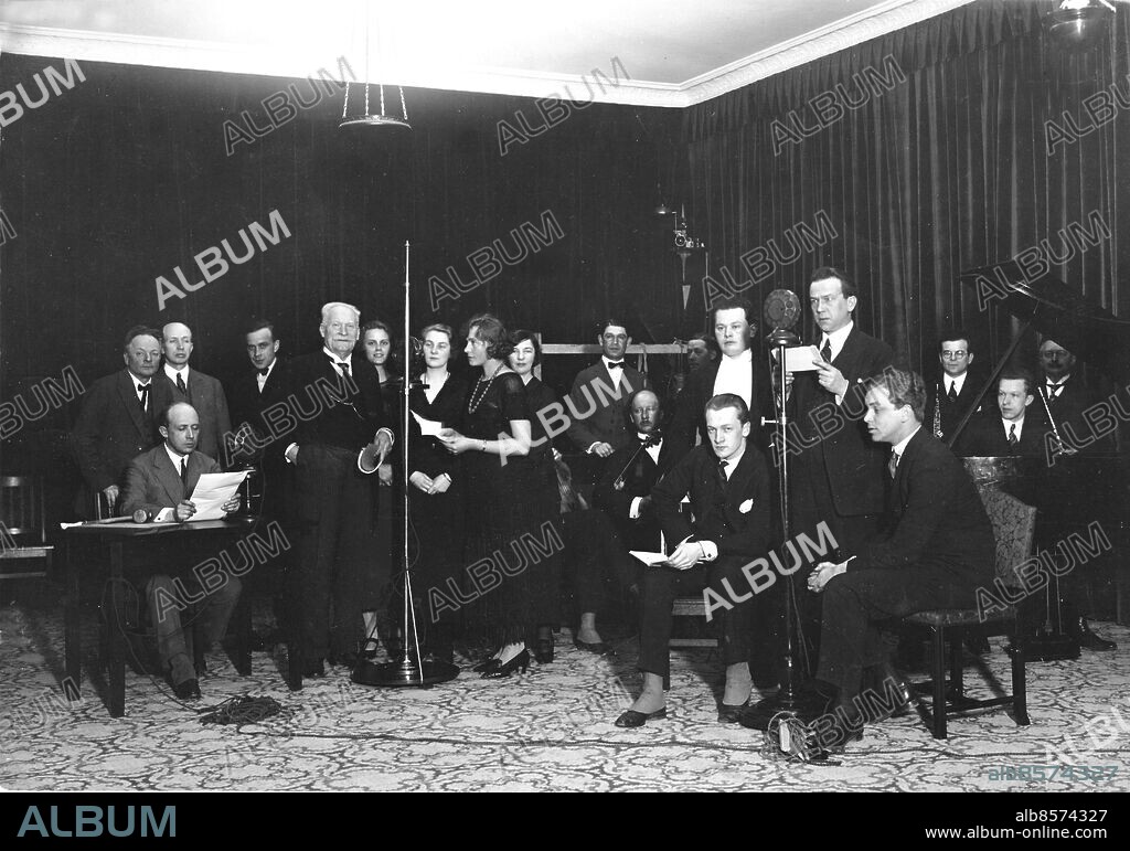 Not. 1925 12/4 Det gammla spelet om Envar En av radiotjänsts första teaterföreställningar. Fr.v. Ivar Nilsson, Gustaf Molander, Olof Molander,Anders Henrikson, Nils Personne, Mona Mårtensson, Signe Enwall,Ebba Gard, Elsa Nilsson, sittande vid högra mikrofonen: Alf Sjöberg och Sten Lindgren, stående kapellmästare Säfbom och Axel Högel. Resten av personerna är musiker. Anm. Malmskillnadsgatan 30 Musiker Publ. i boken Hört och sett sid.45 Publ. i RiR 22/80 25-årsboken Studios Inspelningar Regissörer Skådespelare persons: Ivar Nilsson ;Gustaf Molander ;Olof Molander ;Anders Henriksson ;Nils Personne ;Mona Mårtensson ;Signe Enwall ;Ebba Gard ;Elsa Nilsson ;Gerda Lundequist ;Axel Högel ;Alf Sjöberg ;Sten Lindgren sites: SVERIGE.